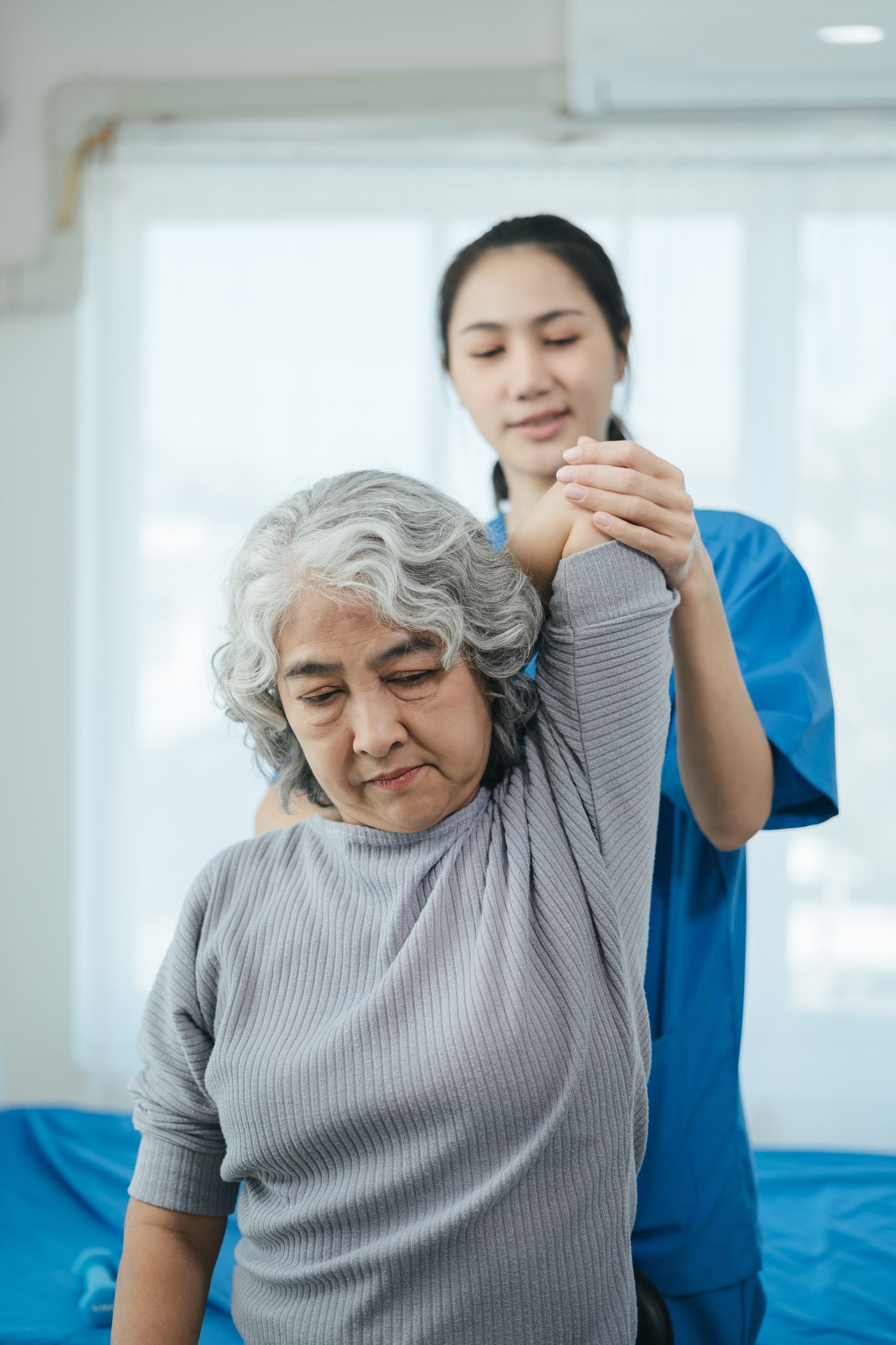 senior woman doing exercise at clinic with physiotherapist. help